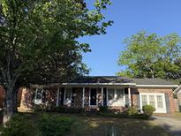 Charming brick home with mature trees and covered front entry at 1138 Landsdowne Dr, Charleston, SC 29412