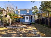 Beautiful backyard with an outdoor kitchen, dining area, and a screened-in porch at 1153 King St, Charleston, SC 29403