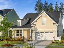Charming home featuring a two-car garage, a well-manicured lawn, and welcoming front porch at 1206 Homecoming Blvd, Ravenel, SC 29470