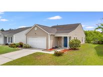 Charming tan home featuring a blue front door, well-manicured lawn, and attached garage at 151 Tyger St, Summerville, SC 29485