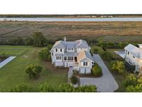 Stunning waterfront home with manicured lawn, mature trees, and a luxurious pool at 1518 Bower Ln, Johns Island, SC 29455