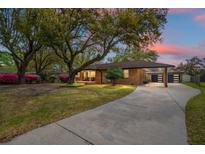Charming brick home with mature trees, covered parking, and a spacious driveway at 1673 Mcclain St, Charleston, SC 29407