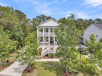 Charming two-story home with double porches surrounded by mature trees and lush landscaping at 2197 Sandy Point Ln, Mount Pleasant, SC 29466