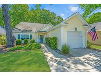 Charming yellow home with a lush front yard and inviting curb appeal at 2418 Tuscany Dr, North Charleston, SC 29406