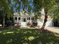 Charming home with a well-manicured lawn, mature trees, and a welcoming front porch at 255 Oak Point Landing Dr, Mount Pleasant, SC 29464