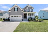 Charming two-story home with a manicured lawn, inviting front porch, and attached two-car garage at 2827 Wagner Way, Mount Pleasant, SC 29466