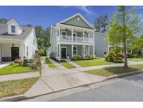 Charming two-story home with a double porch, tidy lawn, and landscaped yard at 3191 Moonlight Dr, Charleston, SC 29414
