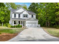 Beautiful two-story white home with a well-manicured lawn and a long driveway leading to an attached two-car garage at 3361 Olivia Marie Ln, Johns Island, SC 29455