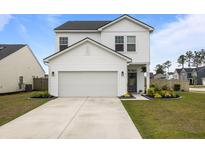 Charming two-story white home featuring a two-car garage and well-maintained landscaping at 401 Carrara Dr, Summerville, SC 29486