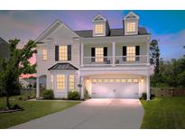 Charming two-story home boasts a two-car garage, second-story balcony, and manicured lawn, perfect for modern living at 4024 Exploration Rd, Ladson, SC 29456