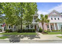 Charming multi-story homes with inviting front porches, manicured lawns and attractive landscaping creating a vibrant neighborhood street view at 404 Forsythia Ave, Summerville, SC 29483