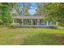 Charming one-story home featuring a cozy front porch and well-maintained lawn at 4942 Storage Rd, Meggett, SC 29449