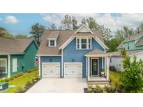 Charming blue two-story home with white trim, two-car garage, and landscaped front yard at 518 Sound Dr, Summerville, SC 29486