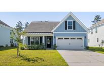 Charming blue home featuring a two-car garage and well-manicured front lawn at 603 Yellow Leaf Ln, Summerville, SC 29486