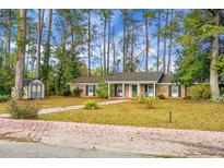 Charming brick home with a classic design, complemented by mature trees and a well-manicured front yard at 702 Minus St, Saint George, SC 29477