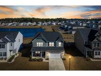 Beautiful home exterior with a lake view, complemented by lush greenery and situated in a serene neighborhood at 705 Squire Pope Rd, Summerville, SC 29486