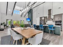 Open-concept living room with modern kitchen, dining area, high ceilings, and large windows offering plenty of natural light at 733 Oakridge View Trl, Ridgeville, SC 29472