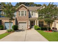 Charming townhome with a stone facade, inviting front porch, and well-manicured landscaping at 849 Bibury Ct, Charleston, SC 29414