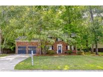 Charming brick home with an attached two-car garage and lush greenery in a well-maintained front yard at 103 Sylvan Ter, Summerville, SC 29485