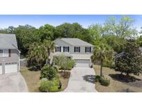 Traditional two-story home with neutral siding, black shutters, palm trees, and a well-manicured lawn at 1087 Clearspring Dr, Charleston, SC 29412