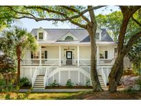 Charming two-story home with a classic front porch and lush, mature trees at 1483 Harborsun Dr, Charleston, SC 29412