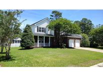 Charming two-story home with brick accents, a covered porch, and a well-manicured lawn at 15 Muirfield Village Ct, Summerville, SC 29483