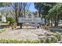 A welcoming Woodhill Place sign indicates a private residential community with mature trees and manicured landscaping at 2030 Coldspring Dr # 708, North Charleston, SC 29406