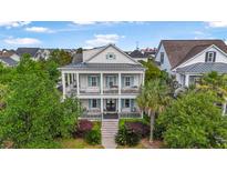 Charming two-story home with double porches, blue shutters, and manicured landscaping offers classic Southern charm at 2522 Daniel Island Dr, Daniel Island, SC 29492