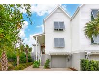 Charming two-story home with white siding, garage, louvers, and lush landscaping at 2578 Helmsman Rd, Johns Island, SC 29455