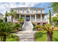 Stately two-story home featuring a grand staircase, covered porch, and lush, tropical landscaping at 2645 Crooked Stick Ln, Mount Pleasant, SC 29466