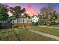 Charming single-story home with a brick foundation, blue shutters, and lush green lawn at dusk at 4515 Holmes Ave, North Charleston, SC 29405