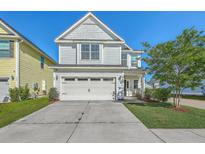 Two story home with a two car garage, well manicured lawn and landscaping, and bright blue sky at 508 Alderly Dr, Moncks Corner, SC 29461