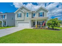 Charming two-story home featuring a well-manicured lawn, attached garage, and a welcoming front porch at 511 Nandina Dr, Goose Creek, SC 29445