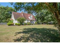 Charming home with a well-manicured lawn and mature trees offers classic curb appeal at 5615 Highway 165, Ravenel, SC 29470
