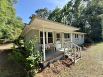 Charming home with a cozy front porch and brick foundation, bench, and updated railing at 6086 Chisolm Rd, Johns Island, SC 29455