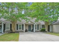 Charming home featuring a well-maintained lawn, mature trees, and welcoming curb appeal at 7999 Vermont Rd, North Charleston, SC 29418