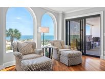 Bright sitting area featuring stylish chairs, ocean views, and access to a private balcony at 9002 Palmetto Dr # 119, Isle of Palms, SC 29451