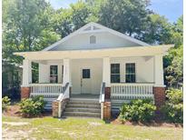 Charming white craftsman-style home with a welcoming front porch and manicured landscaping at 107 Tracy St, Walterboro, SC 29488