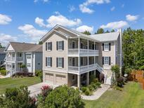 Beautiful three-story home with double porches, two-car garage, and manicured landscaping at 118 Wando Reach Rd, Wando, SC 29492