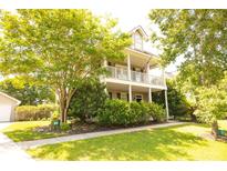 Charming two-story home featuring a welcoming front porch and lush landscaping, plus attached garage at 120 Full Moon Ct, Ladson, SC 29456