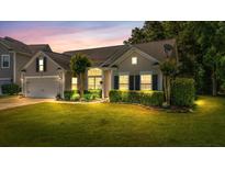Charming single-Gathering home featuring a manicured lawn and lush landscaping at dusk at 124 Corral Cir, Summerville, SC 29485