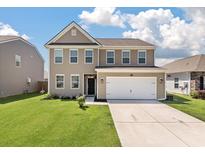 Charming two-story home features a two-car garage, neutral siding, and well-maintained lawn at 1311 Berry Grove Dr, Summerville, SC 29485
