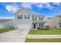 Charming two-story home with gray siding, attached garage, landscaped yard, and inviting front porch, perfect for relaxing outdoors at 134 Lucca Dr, Summerville, SC 29486