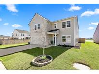 Charming two-story home with a well-maintained lawn and classic siding under a clear blue sky at 142 Lucca Dr, Summerville, SC 29486