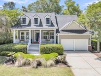 Charming home featuring a welcoming porch, landscaped front yard, and a two-car garage at 1733 James Basford Pl, Mount Pleasant, SC 29466