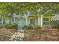 Charming two-story home features a manicured lawn, walkway lighting, and a private second-floor balcony at 1781 Brittlebush Ln, Johns Island, SC 29455