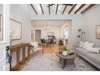Open concept living room features a decorative rug, light gray sofa, and exposed beam ceiling at 301 Beaufort St, Summerville, SC 29483