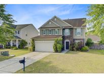 Charming two-story home featuring a manicured lawn, stone accents and a two-car garage at 330 Albrighton Way, Moncks Corner, SC 29461