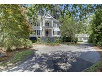 Two-story home featuring a double balcony, manicured landscaping, and circular driveway for curb appeal at 418 W Carolina Ave, Summerville, SC 29483