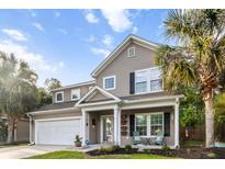 Charming two-story home with a landscaped front yard, inviting porch, and attached two car garage at 5022 W Liberty Meadows Dr, Summerville, SC 29485